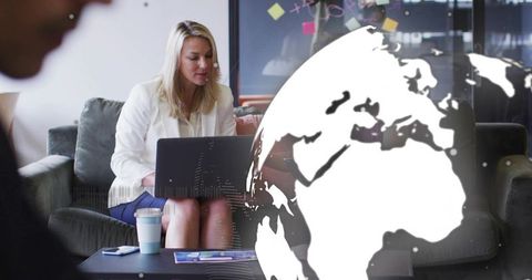 Female professional working on laptop in coworking lounge with global network overlay