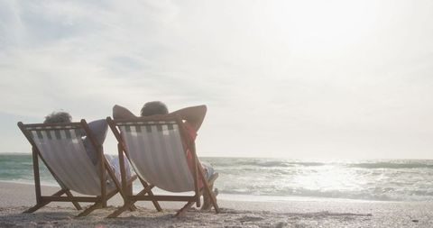 Senior couple enjoying beachfront relaxation at sunset
