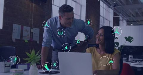 Team collaborating on sustainable tech strategy with eco icons and laptop in modern office
