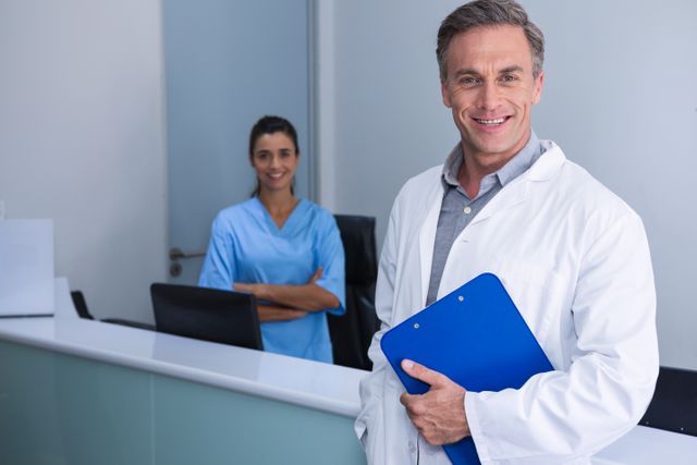 Portrait of smiling doctors standing against wall - Download Free Stock Photos Pikwizard.com