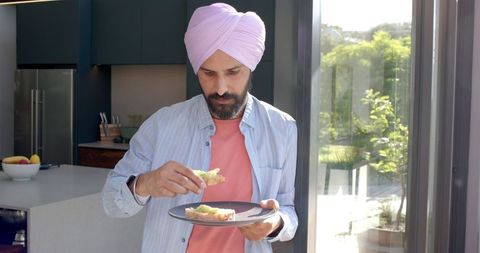 Turbaned Man Making Avocado Toast in Modern Home Kitchen
