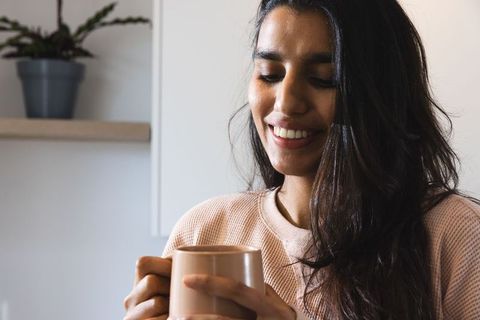 Woman Relaxing with a Warm Mug in Minimalistic Kitchen