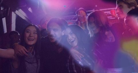 Friends Capturing Nightclub Party Moments under Neon Lights