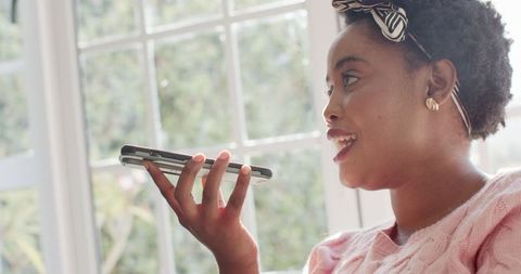 Joyful Woman Engaged in Energetic Phone Conversation at Home