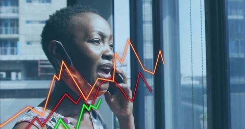 Businesswoman managing analytics with smartphone by office window