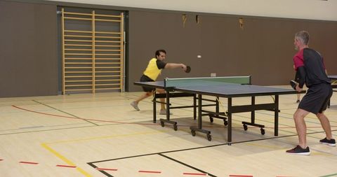 Male Players Active Ping Pong Match in Indoor Gym