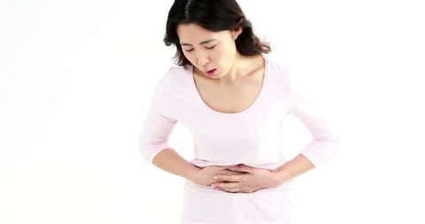 Woman Suffering from Stomach Pain with Hands on Abdomen