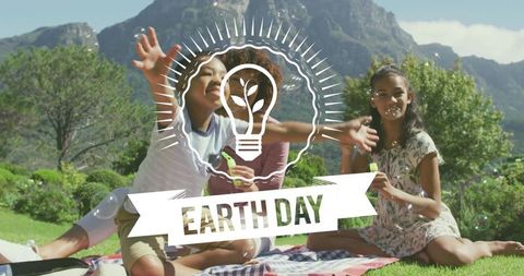Family Celebrating Earth Day Outdoors Blowing Bubbles on Mountain Picnic Blanket