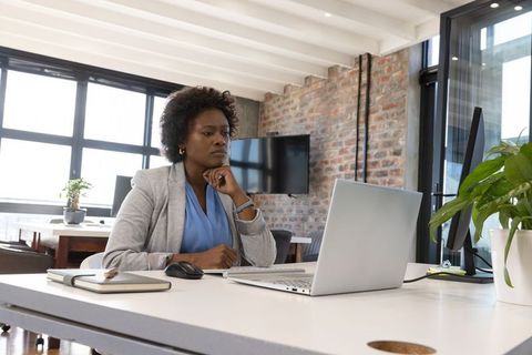 Focused Businesswoman Working at Laptop in Modern Office Environment