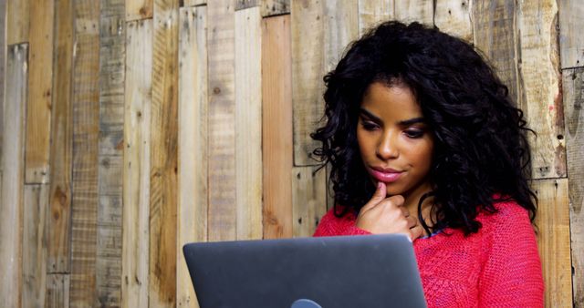 Focused Woman Working on Laptop Against Wooden Wall - Download Free Stock Images Pikwizard.com