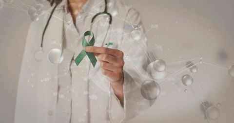 Clinician holding green awareness ribbon with stethoscope and molecular network for health campaign
