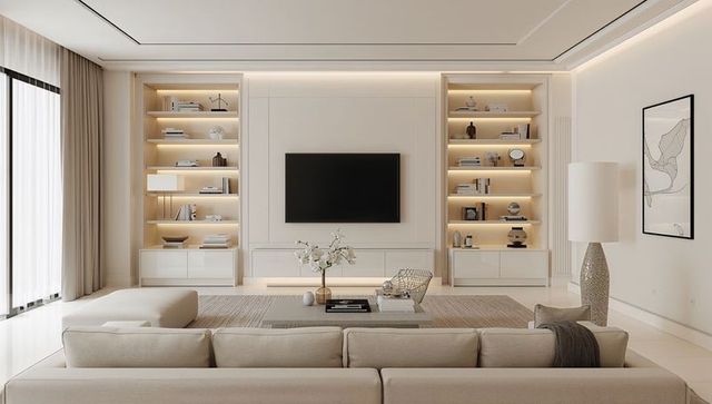 Featuring beige sectional sofa facing wall-mounted tv with illuminated built-in shelving