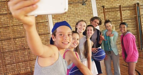 Teenagers Taking Selfie During Basketball Practice in Gym