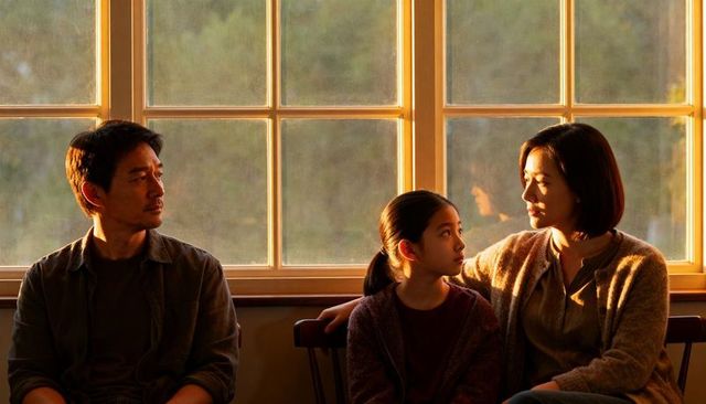 Parents and Daughter Sharing Quiet Golden Hour Moment on Sunlit Bench by Window