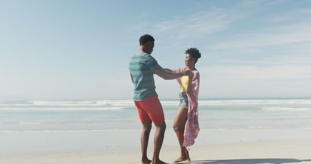 Happy african american couple dancing and holding hands on sunny beach - Download Free Stock Photos Pikwizard.com