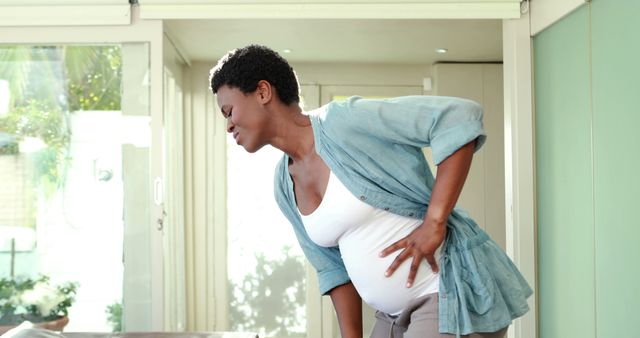 Pregnant Woman Holding Back and Chest in Pain at Home - Download Free Stock Images Pikwizard.com