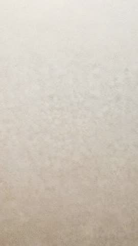 Vertical video featuring beige wall texture for neutral background and ambient mood