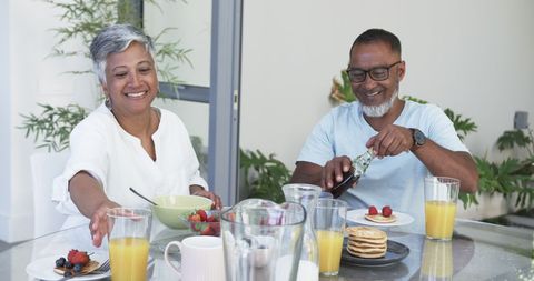 Joyful Couple Savoring Breakfast with Champagne in Modern Space