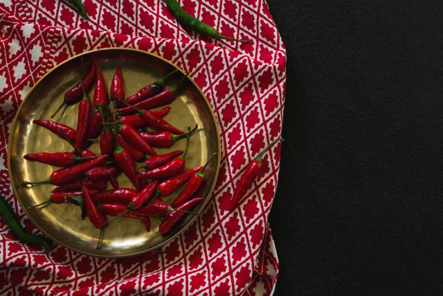 Overhead of red chilies in plate on table cloth