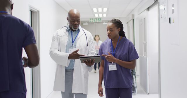 Doctors Discussing Patient Case on Digital Tablet in Hospital Corridor - Download Free Stock Images Pikwizard.com