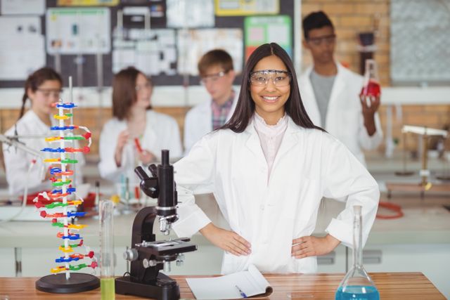 Portrait of school girl standing with hand on hip in laboratory at school