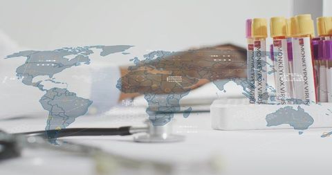 Clinician reaching for monkeypox test tubes on clinic desk with global data overlay