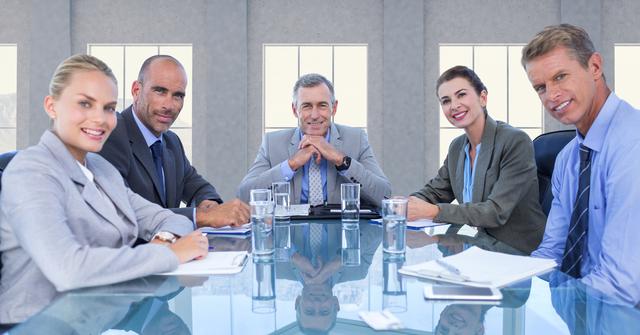 Group of business executives sitting around a table in a modern conference room, showcasing confidence and professionalism. Perfect for themes related to corporate meetings, teamwork, leadership, business discussions, strategic planning, and office settings.