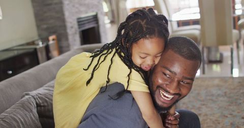 Playful African American Father and Daughter Sharing Happy Moment at Home