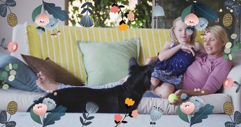 Mother and Daughter Bonding with Dog on Couch