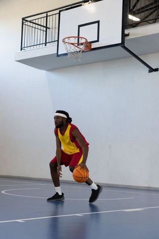 Athlete in Basketball Practice Dribbling on Indoor Court