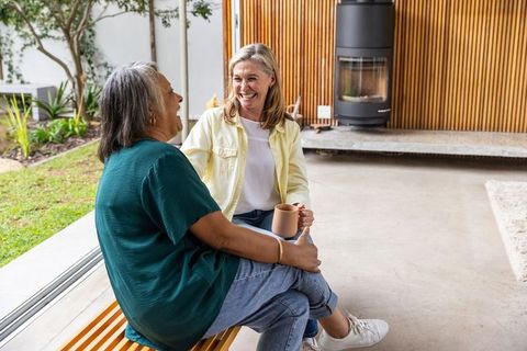 Senior Friends Sharing Laughter and Coffee on Outdoor Patio