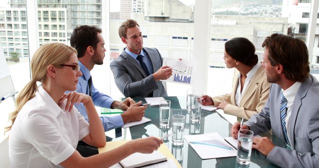 Business team engaged in a financial presentation in a modern office - Download Free Stock Images Pikwizard.com