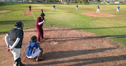 Amateur baseball game on sunny day from behind home plate