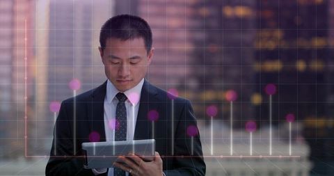 Asian executive analyzing financial data on tablet with digital graph overlay rooftop twilight skyli
