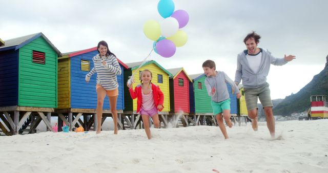 Family Enjoying Beach Fun with Balloons Near Colorful Beach Huts - Download Free Stock Images Pikwizard.com