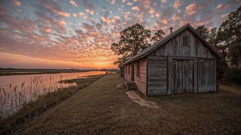 Louisiana rustic wooden cabin by marshland at sunset