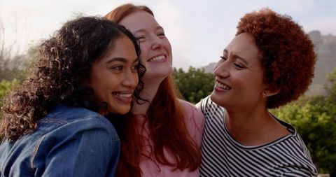Diverse Female Friends Embracing Outdoors on Hillside
