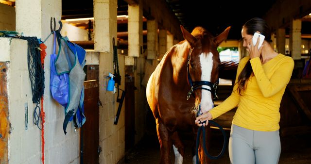 Woman Talking on Phone While Leading Horse in Stable - Download Free Stock Images Pikwizard.com
