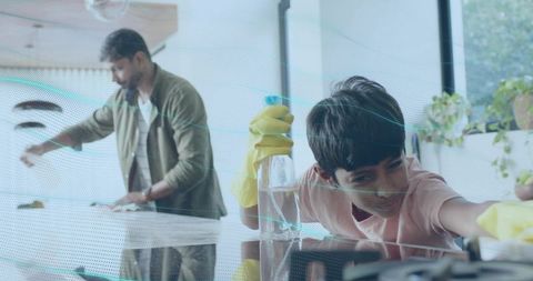 Father and son cleaning glass together, teamwork at home, teaching responsibility