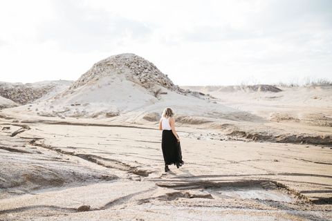 Solitary Woman Walking in Serene Desert Landscape