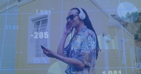 Stylish man in headphones using smartphone with digital overlay