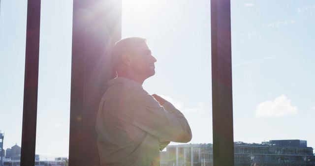 Serene Man Reflecting Next to Sunlit Window - Download Free Stock Images Pikwizard.com