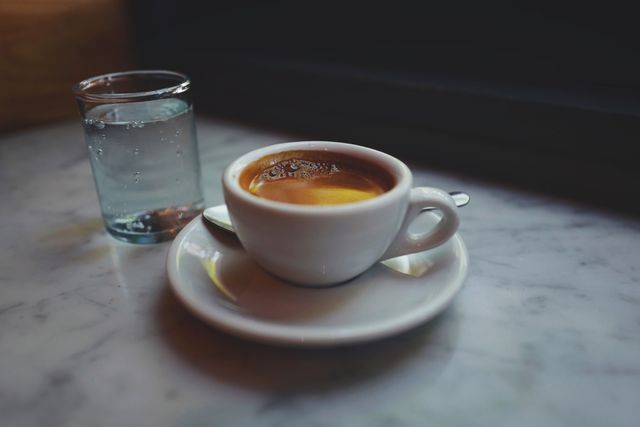 Espresso Cup and Water Glass on Marble Counter in Café - Download Free Stock Photos Pikwizard.com