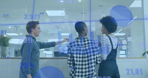 Startup team brainstorming at glass wall with charts, sticky notes, interactive data overlay