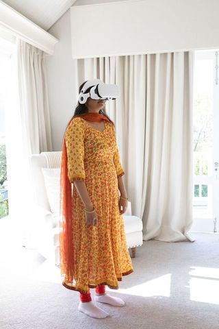 Indian Woman Experiencing Virtual Reality at Home in Vibrant Attire