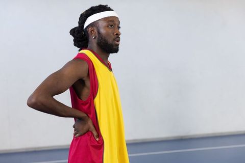 Confident Male Basketball Player Preparing for Game on Indoor Court