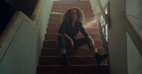 Contemplative Woman Sitting on Dimly Lit Vintage Stairs - Download Free Stock Images Pikwizard.com