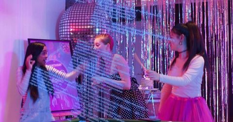 Teen girls celebrating birthday under disco ball with cake, sparkler and digital code overlay