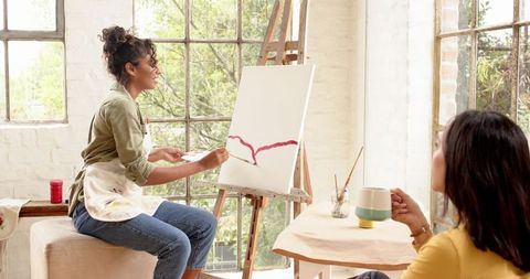 Women enjoying creative painting session in bright art studio