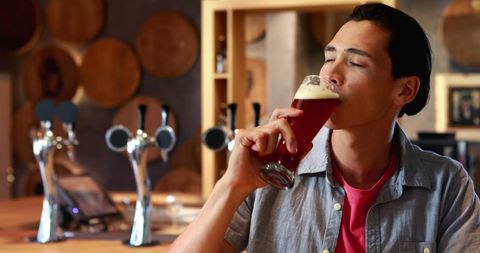 Young Man Enjoying Beer in a Cozy Brewery Environment - Download Free Stock Images Pikwizard.com